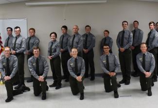 A group of law enforcement students kneel and pose for a picture