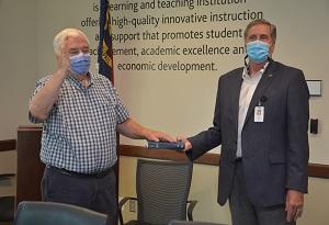 Two men place their hands on a bible